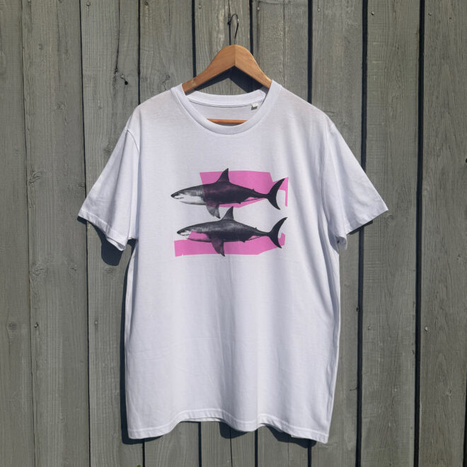 Shark Tank T-shirt - Neon Pink and Black - against wooden backdrop