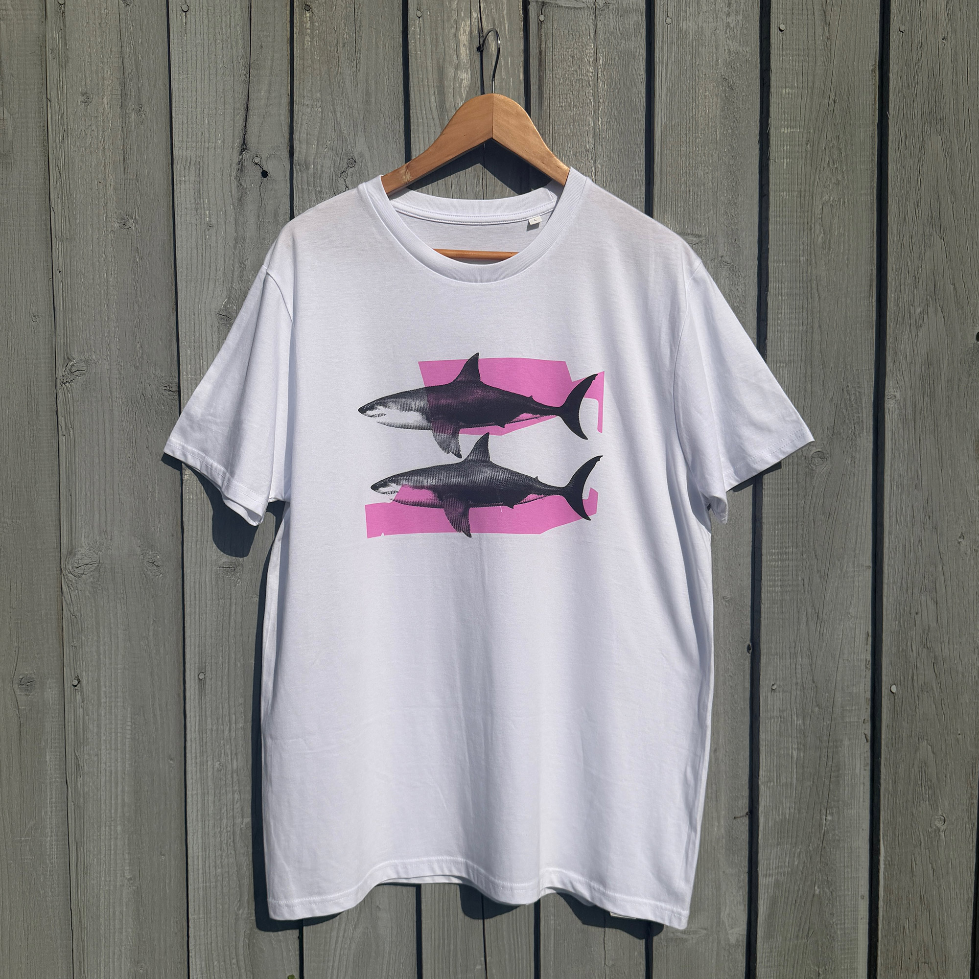 Shark Tank T-shirt - Neon Pink and Black - against wooden backdrop