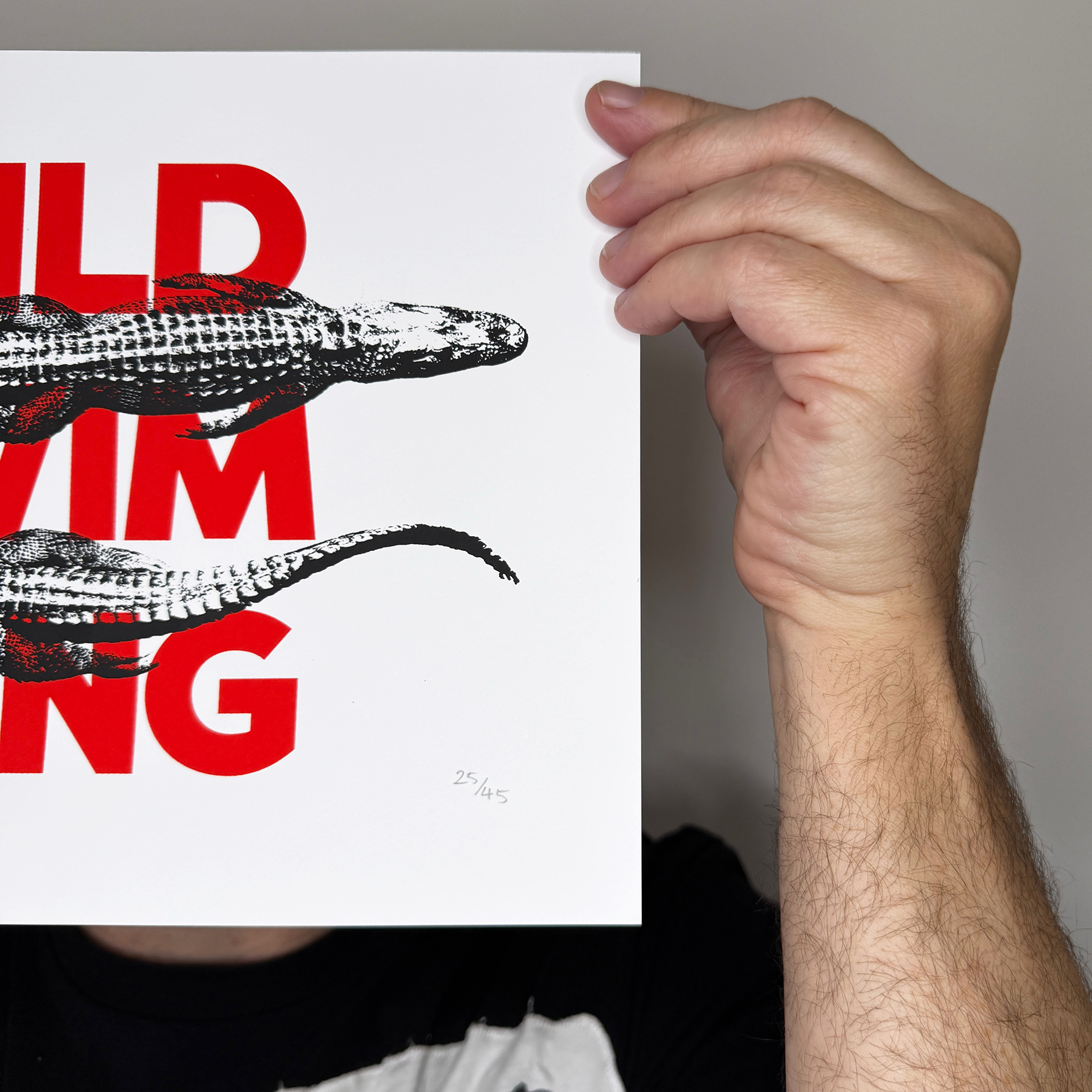 Screen Printed Poster - Wild Swimming_Small A4 Size - close up detail shot right edge. Bold red typography with striking black alligator images.
