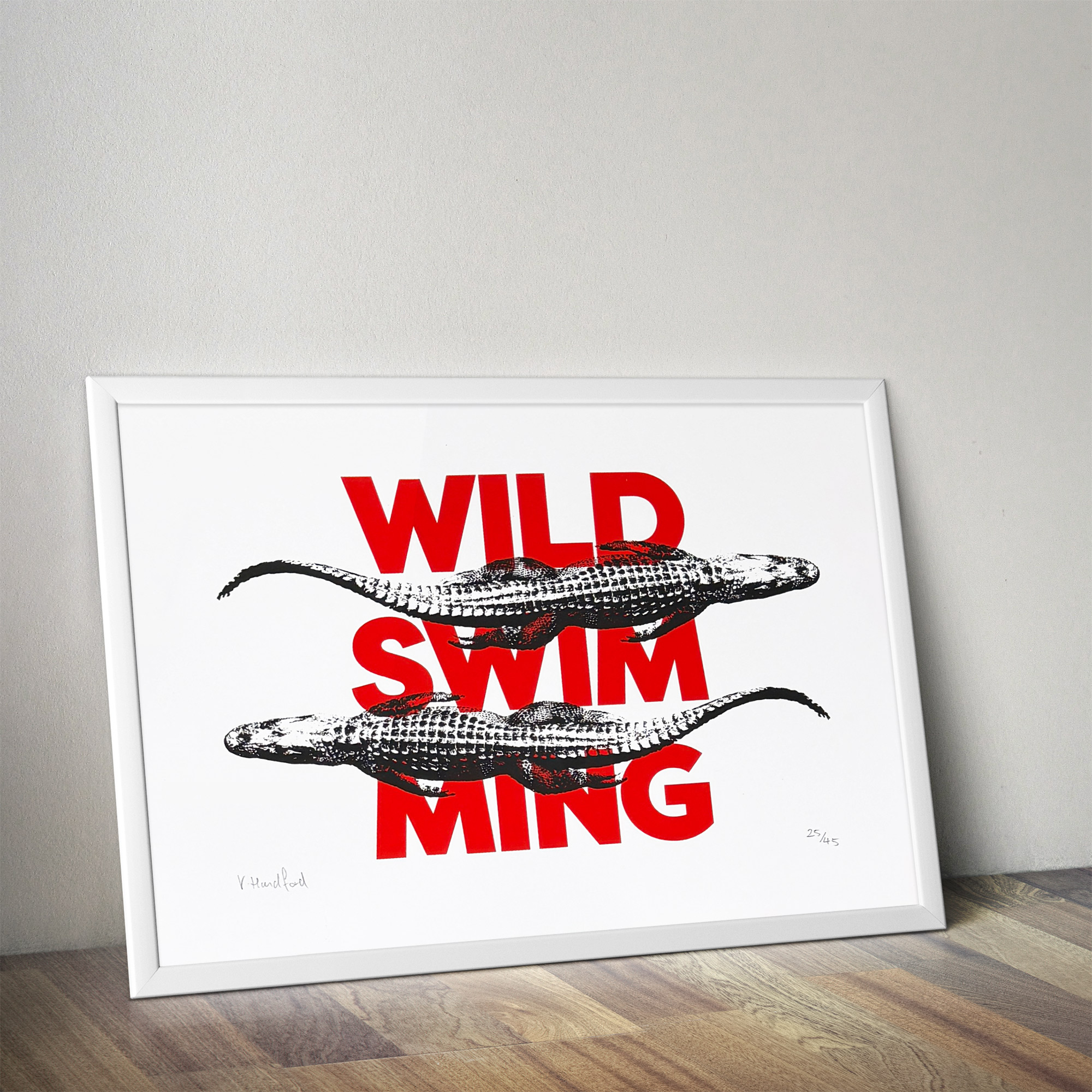 Screen Printed Poster - Wild Swimming_Small A4 Size - mock up in a frame. Bold red typography with striking black alligator images.