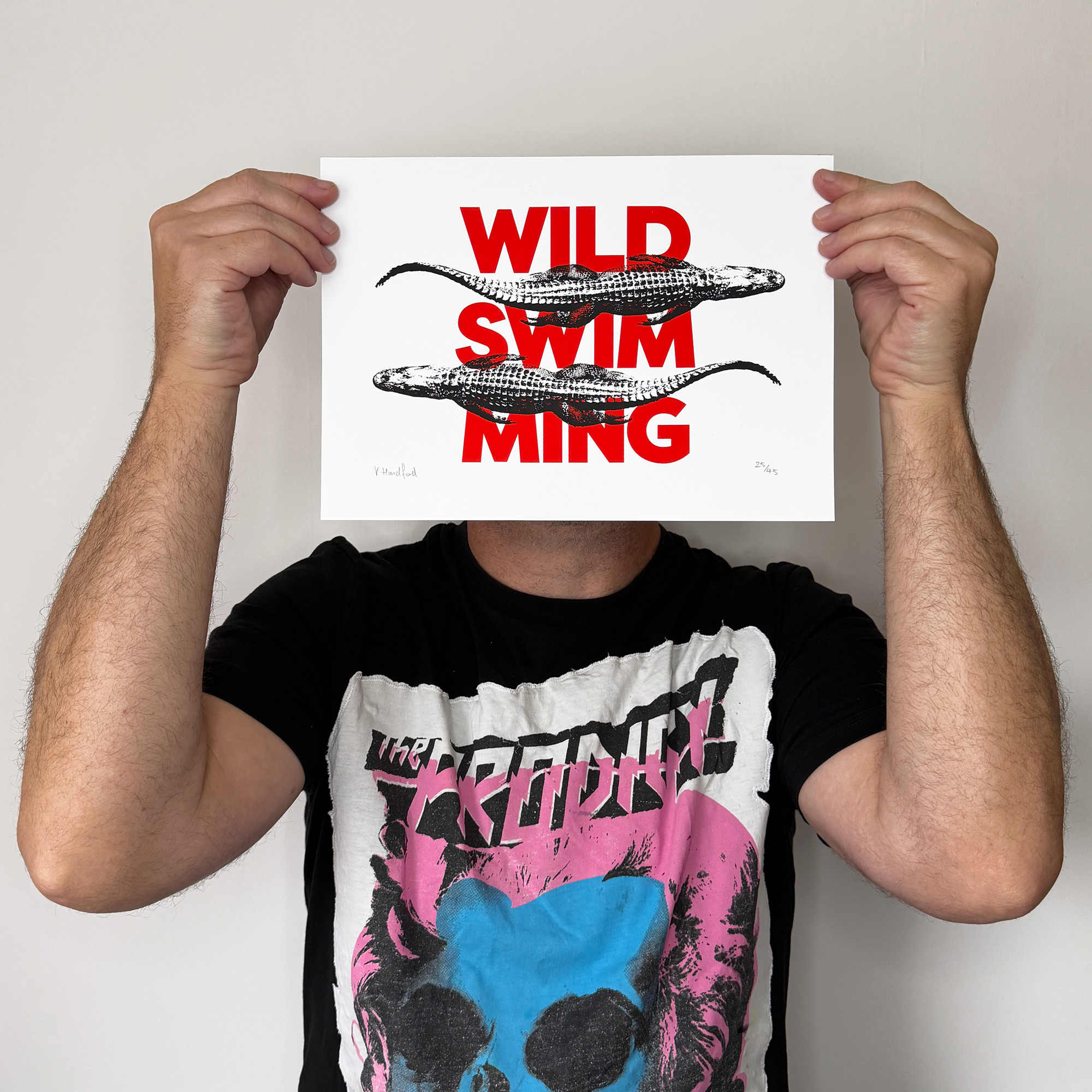 Screen Printed Poster - Wild Swimming_Small A4 Size - scale shot. Bold red typography with striking black alligator images.